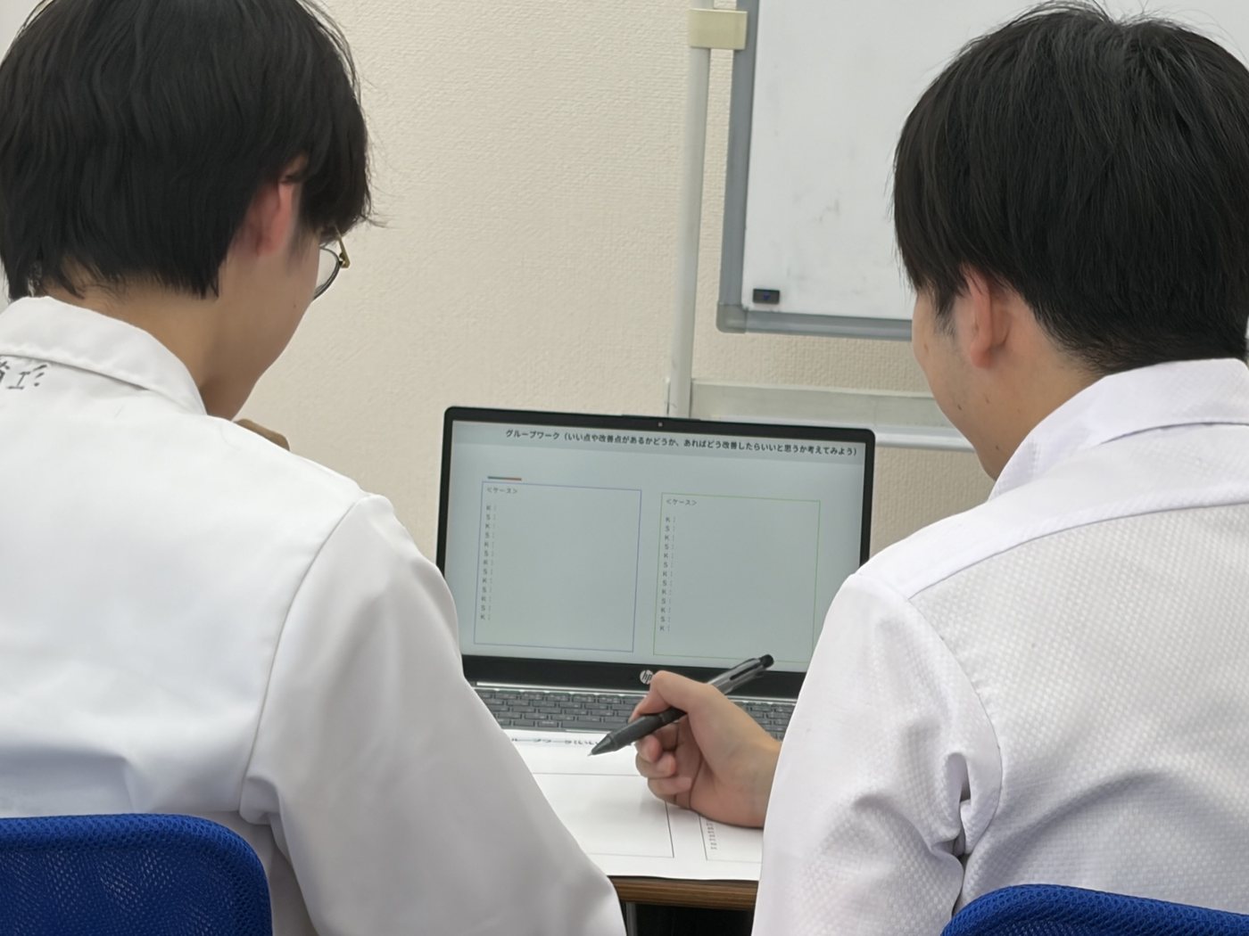 ノートパソコンの画面を見ながら話し合う様子